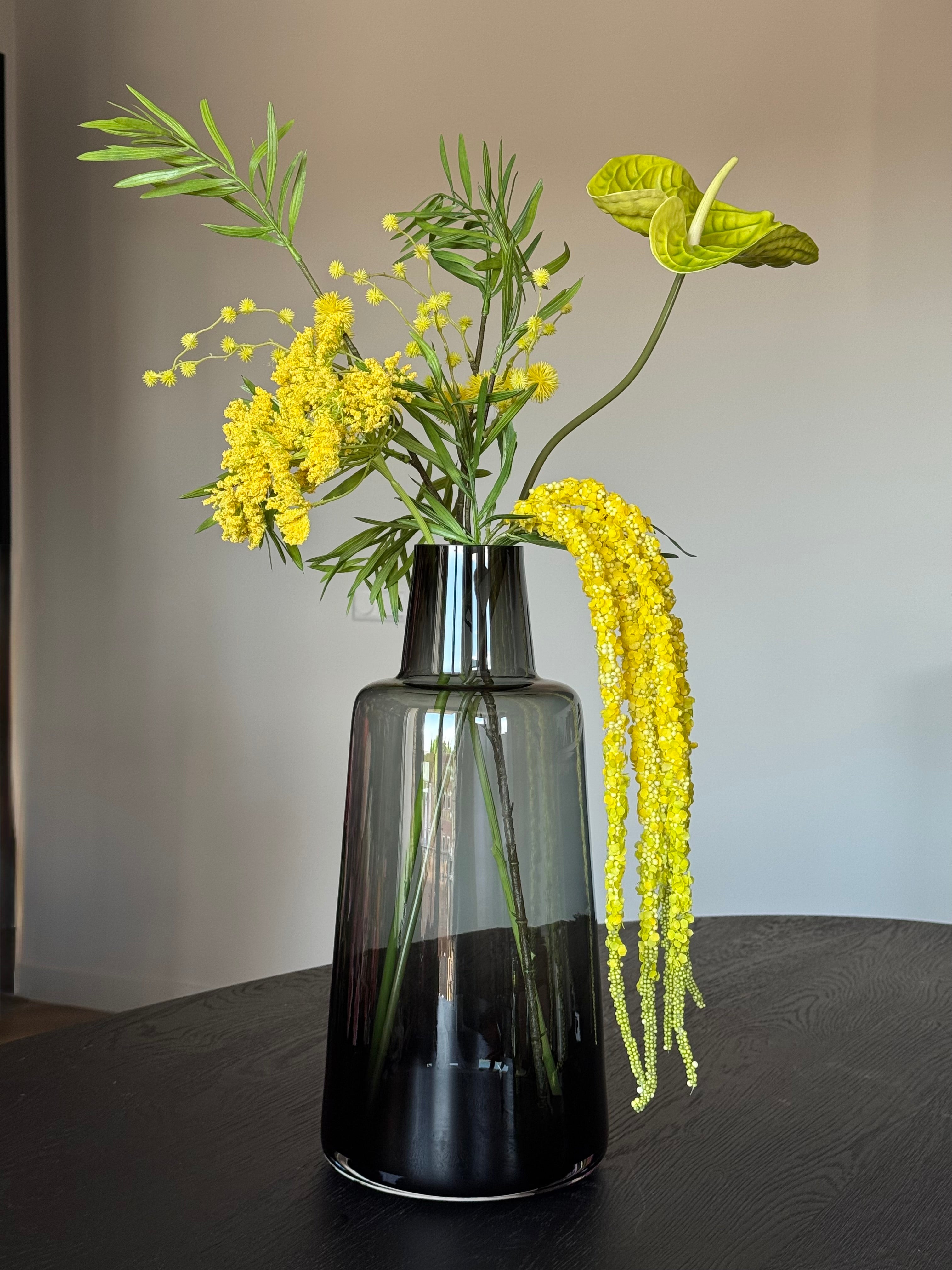 Geel kunstbloemen veldboeket artistiek in zwarte vaas van vase the world