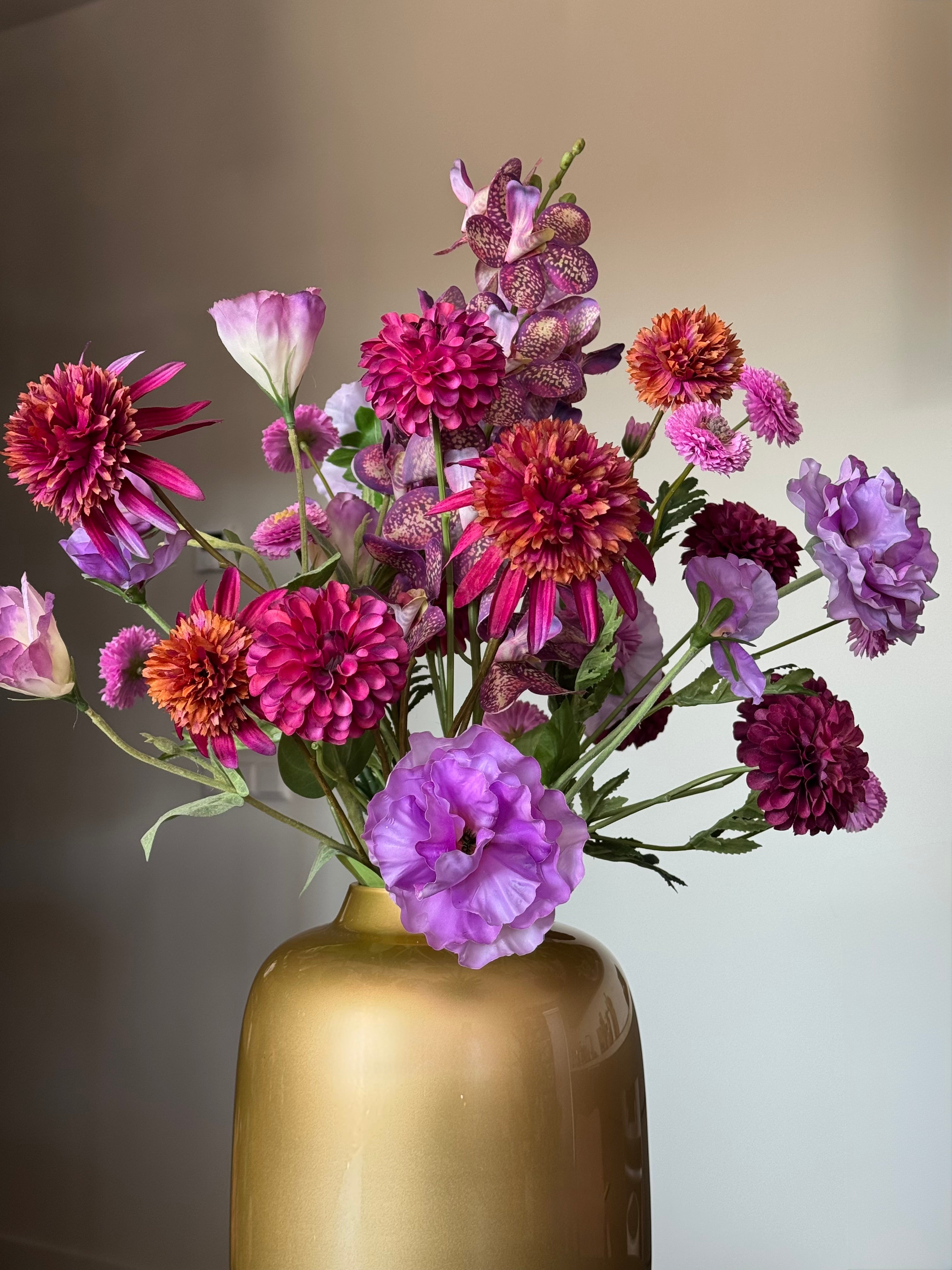 Mooie kunstbloemen in gouden vaas close up