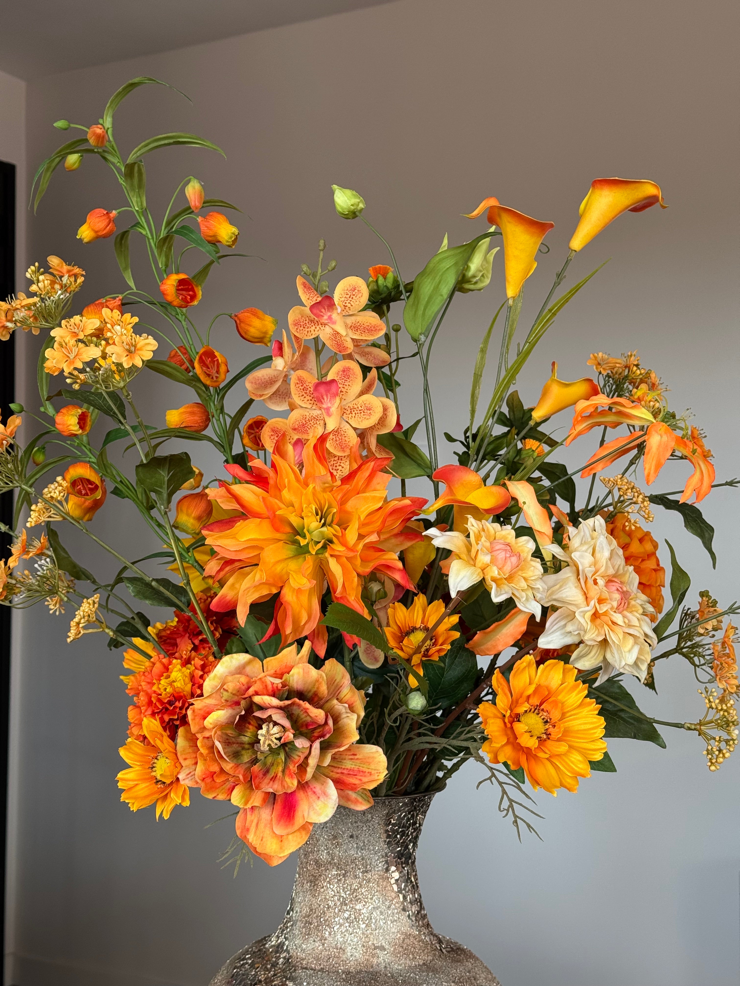 close up van oranje kunstboeket in gouden vaas