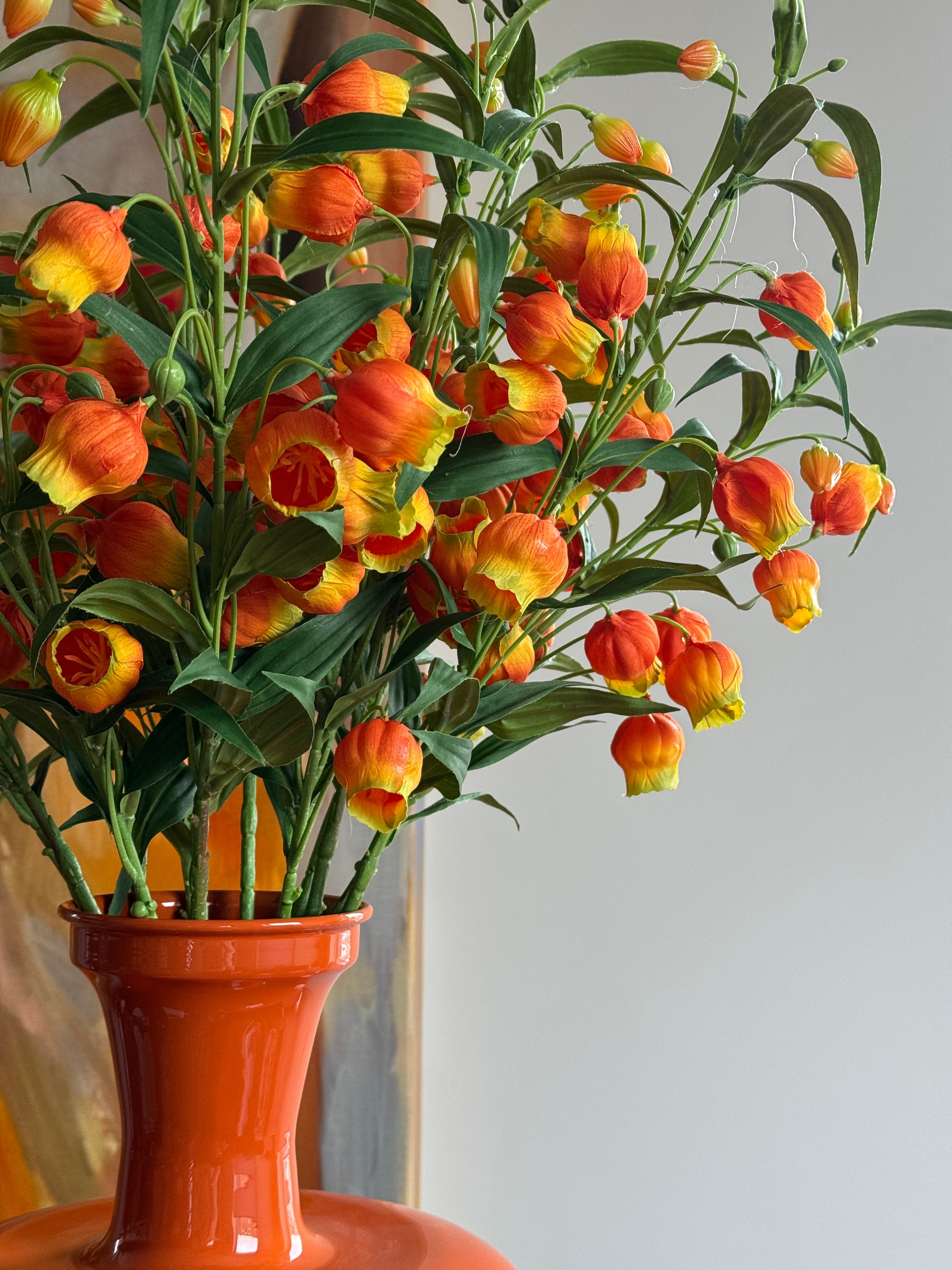 complete tafel accessoire set in oranje met kunstboeket sandersonia close up bloemen