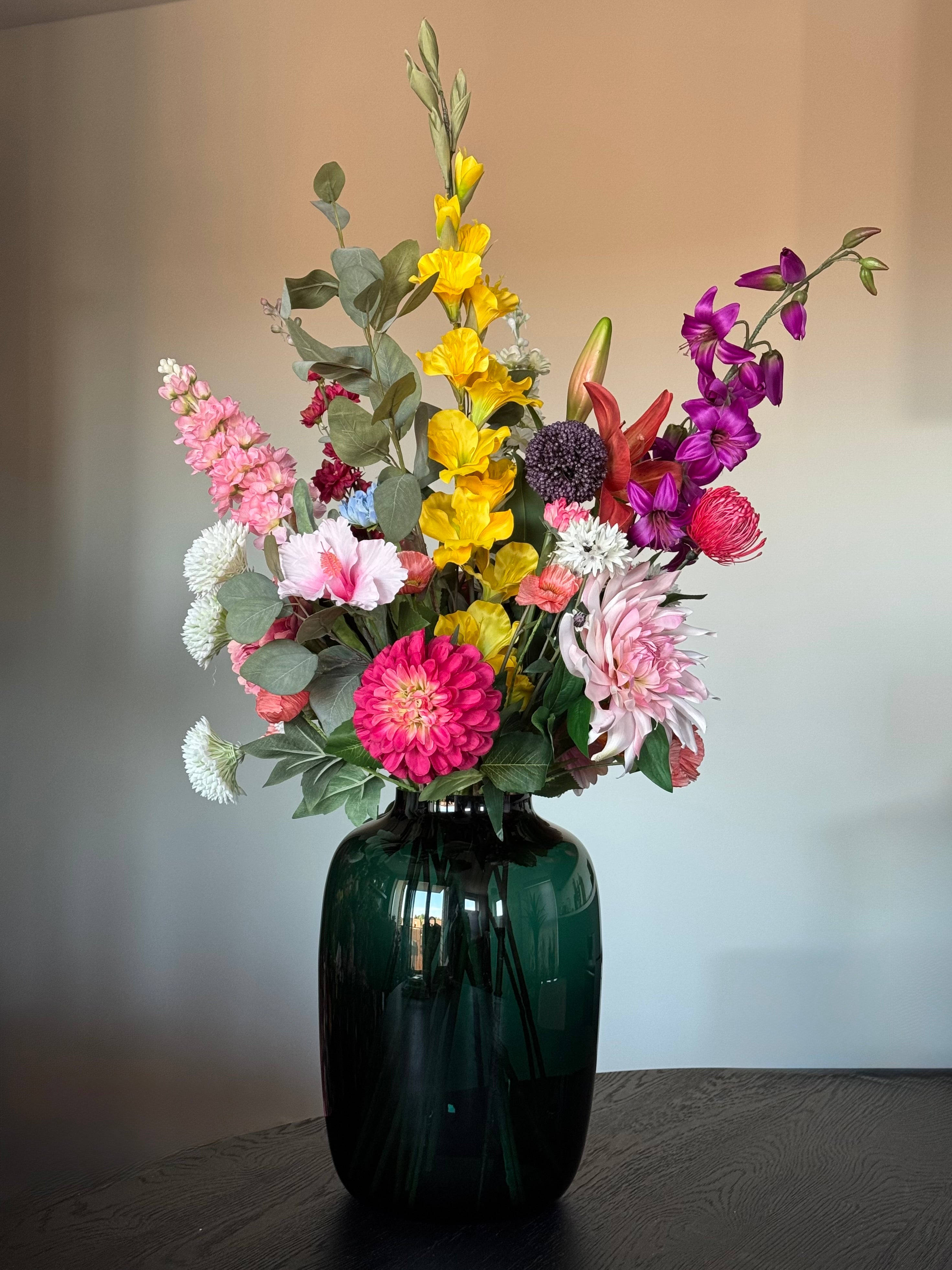 Kleurrijk kunstboeket in grote groene vaas
