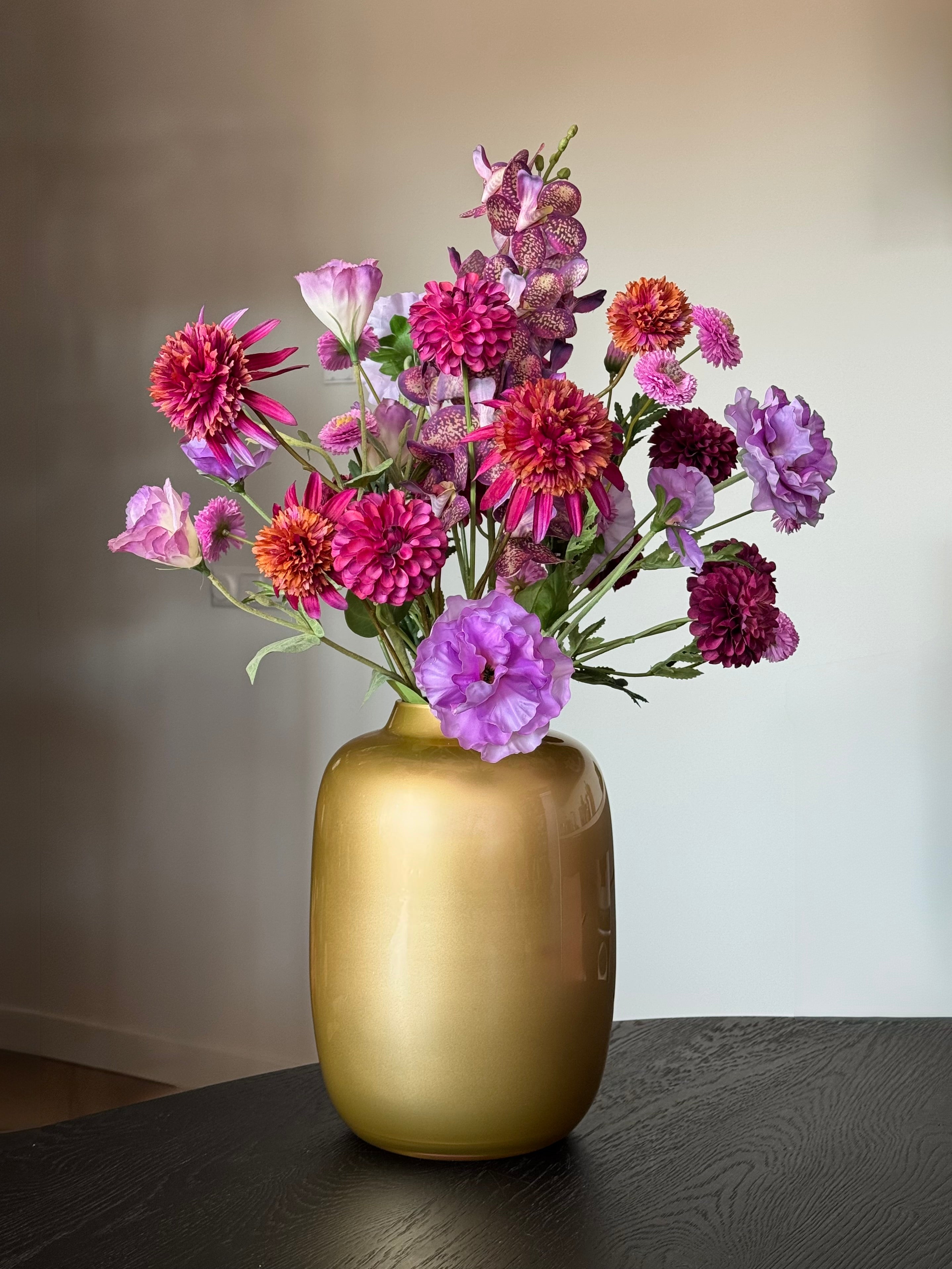 Paars kunstboeket in gouden handgemaakte vaas