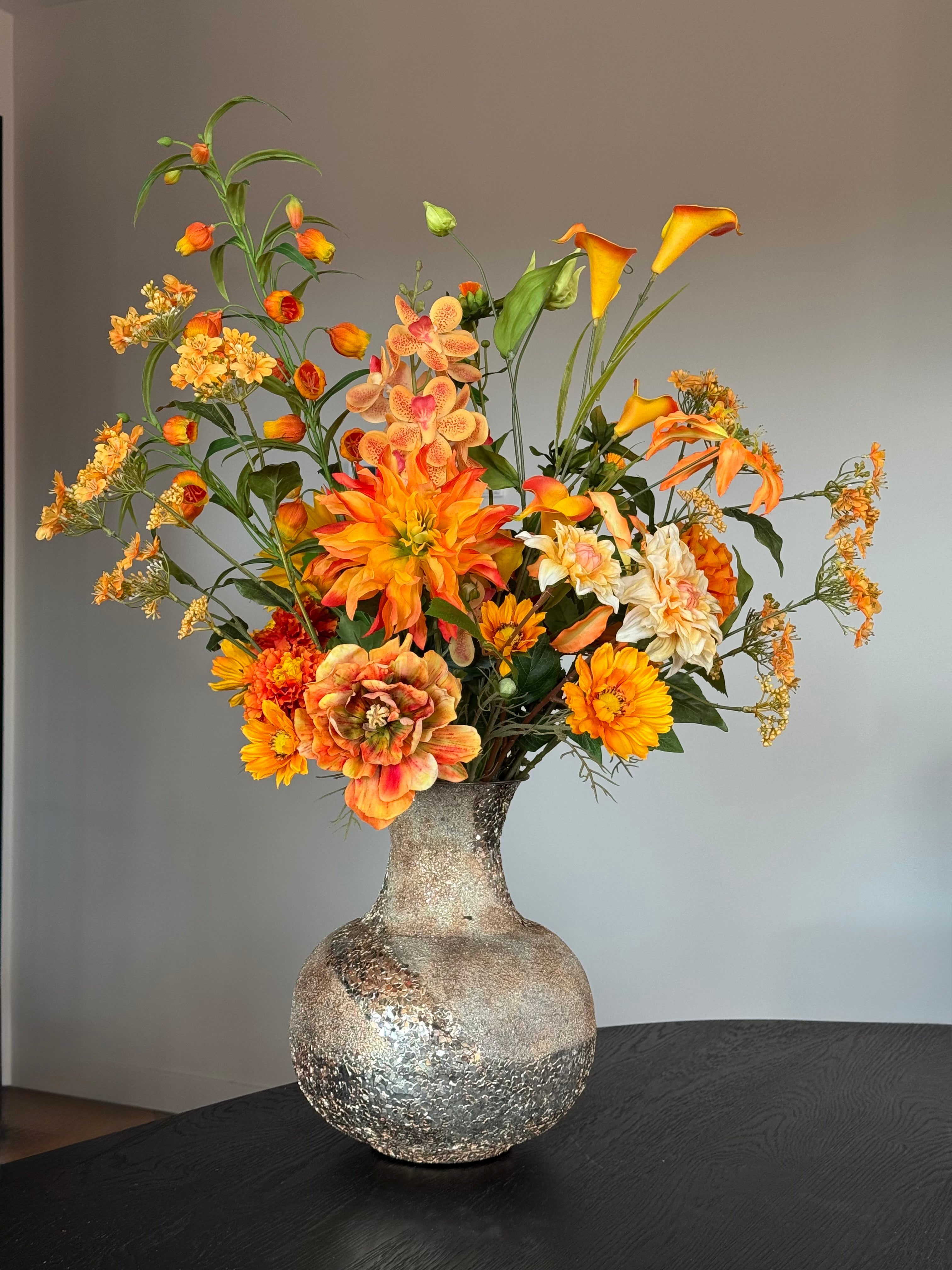 Oranje zijden bloemen boeket in een gouden vaas