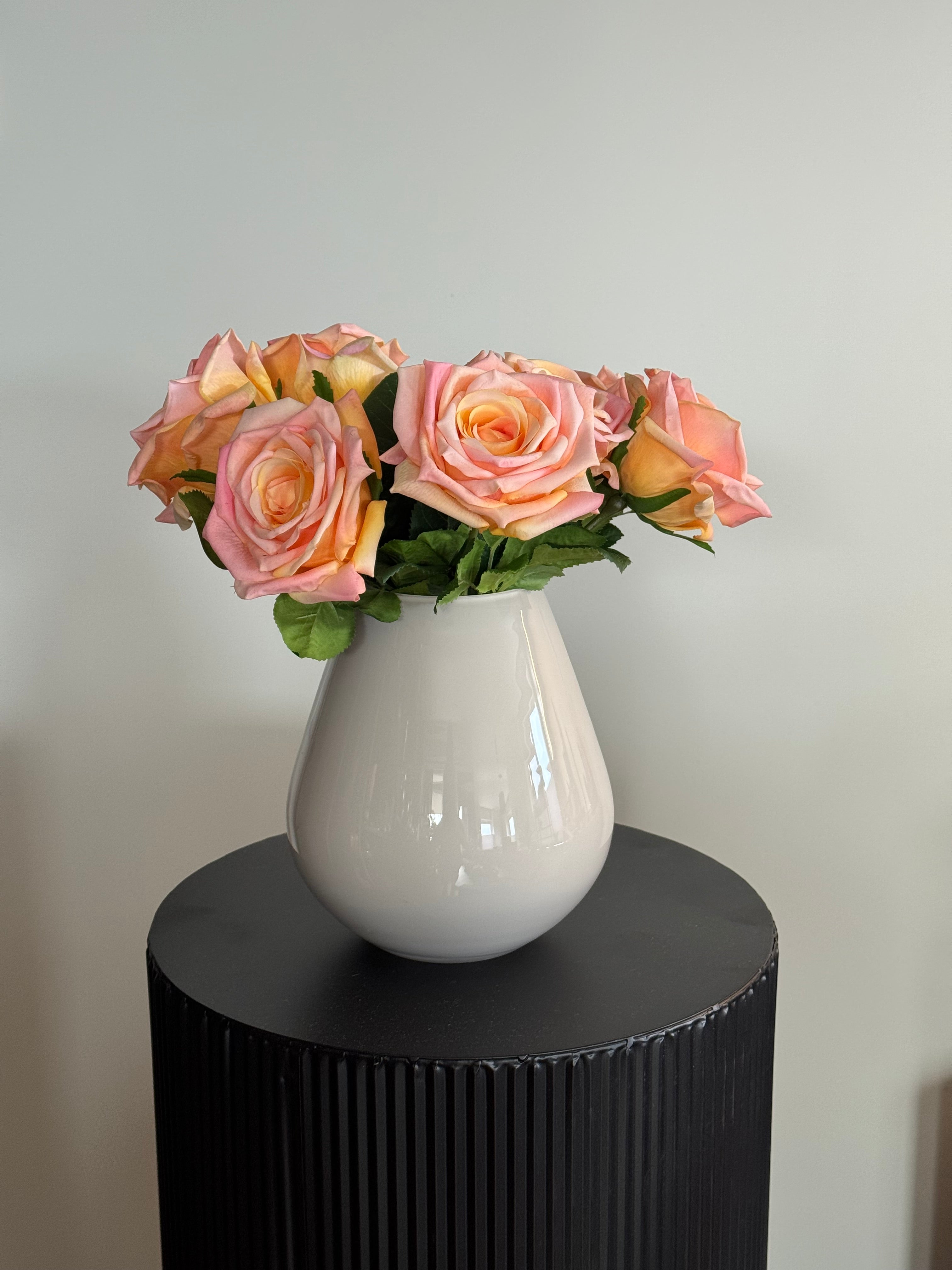 boeket kunstrozen in beige vaas op zwarte display