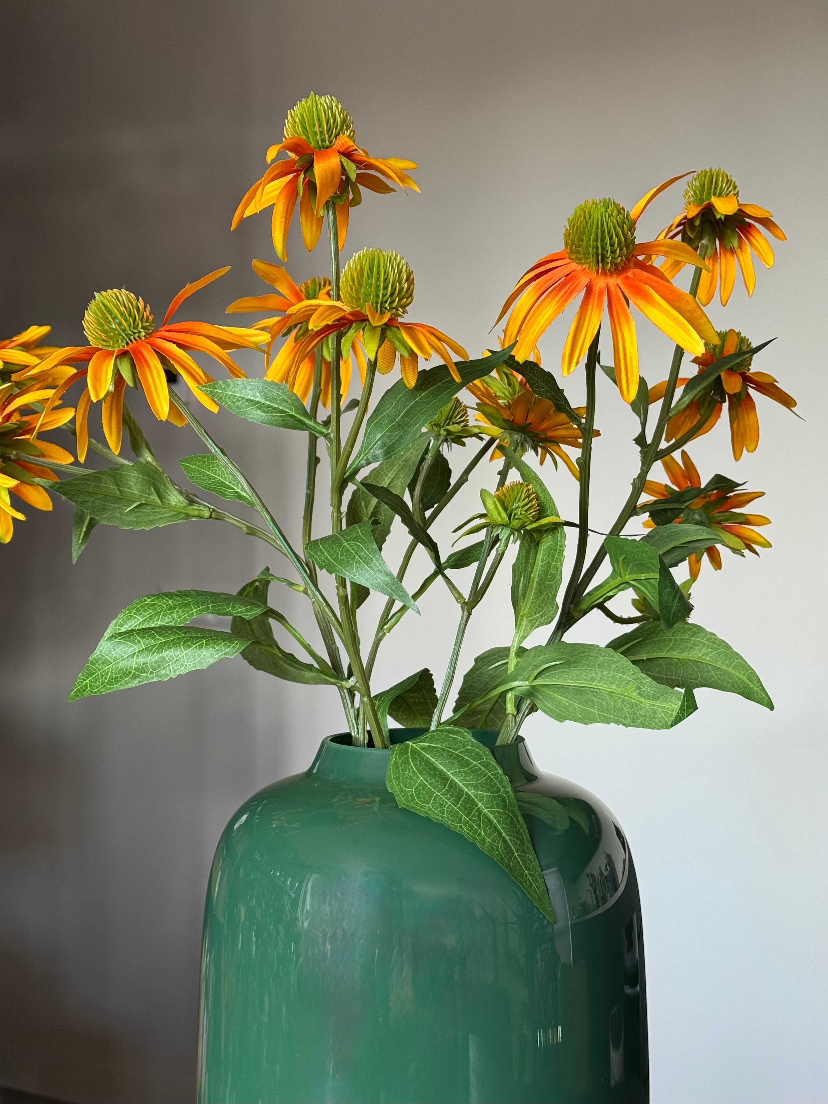 zonnehoed kunsttak in een mondgeblazen groene vaas close up