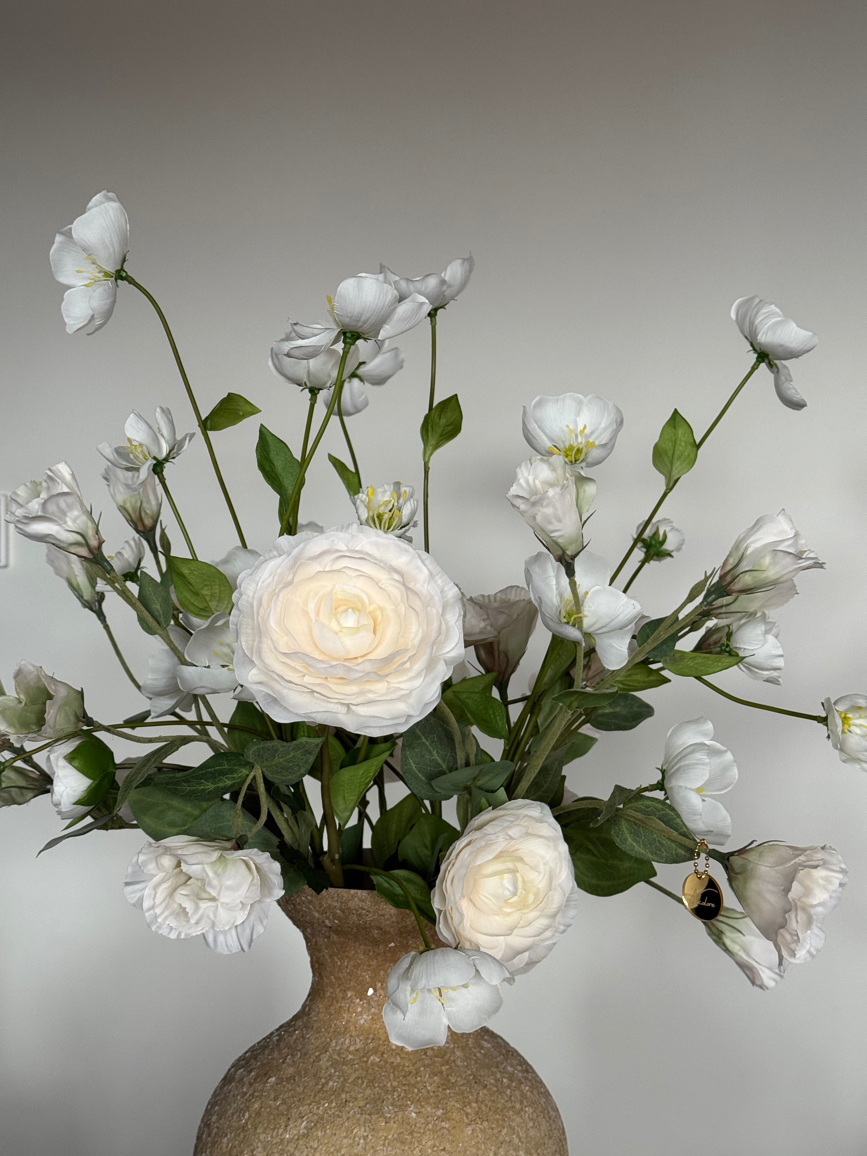 Beige mozaïek vaas met witte zijden bloemen voor een rustig en luxe interieur.