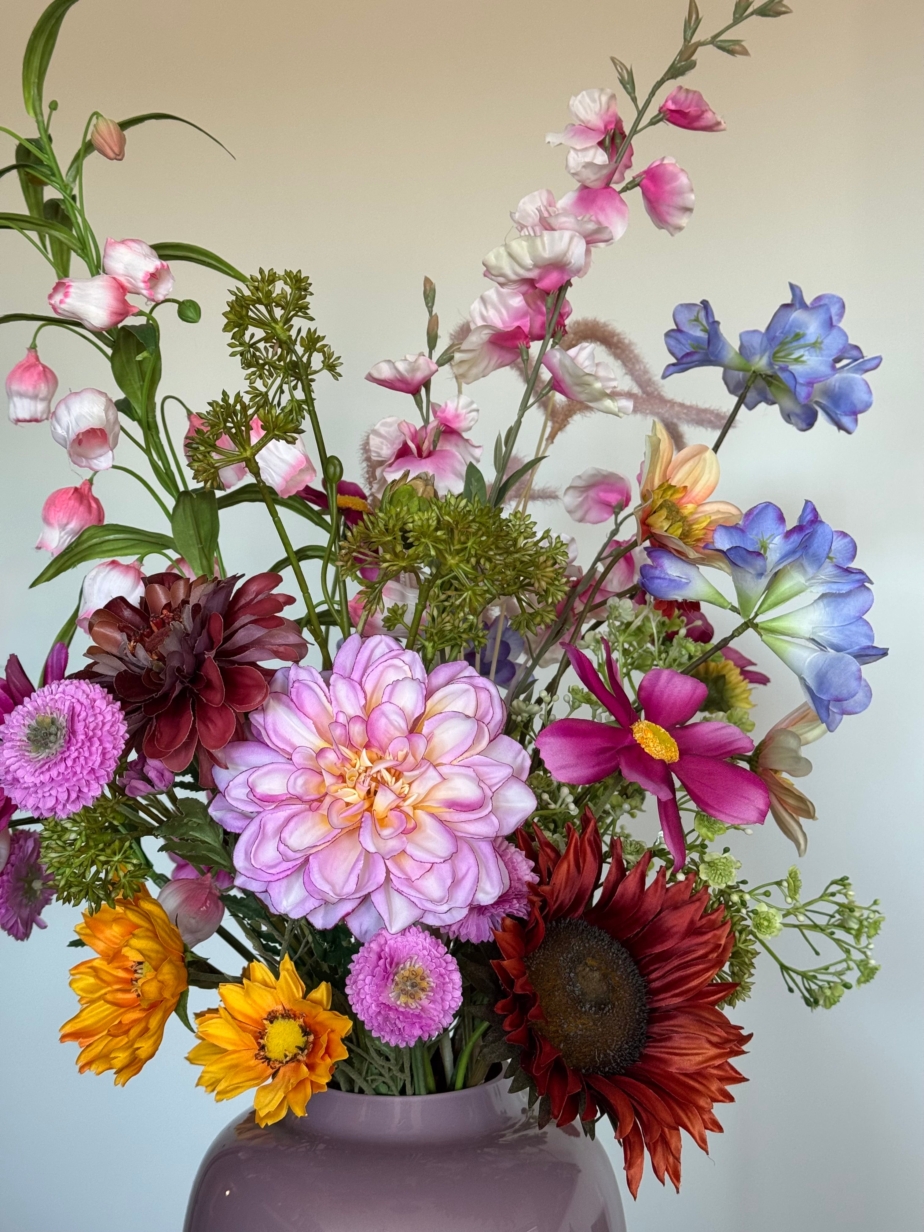 Detail van verschillende kleurrijke zijden bloemen in een vrolijk veldboeket.