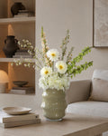 Butter yellow designvaas met artistiek zijden boeket in een modern interieur.