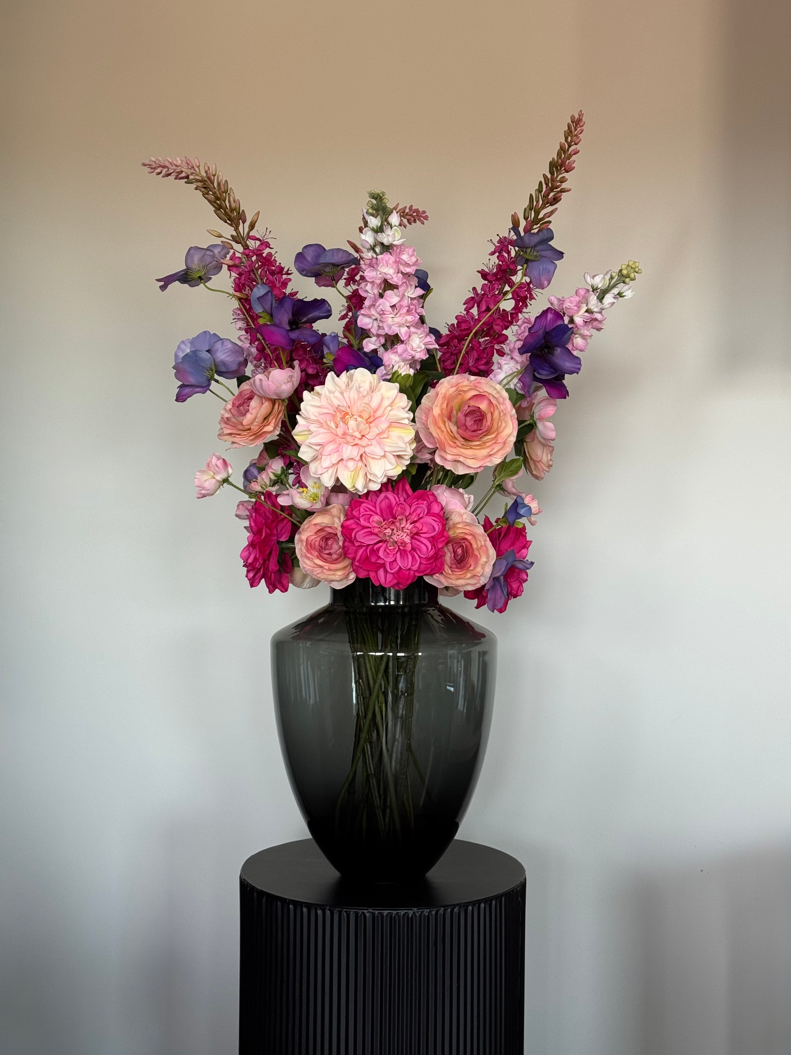 Groot roze zijden boeket Pink Symphony met zwarte designvaas en dahlia's, ranonkels en real touch viooltjes.
