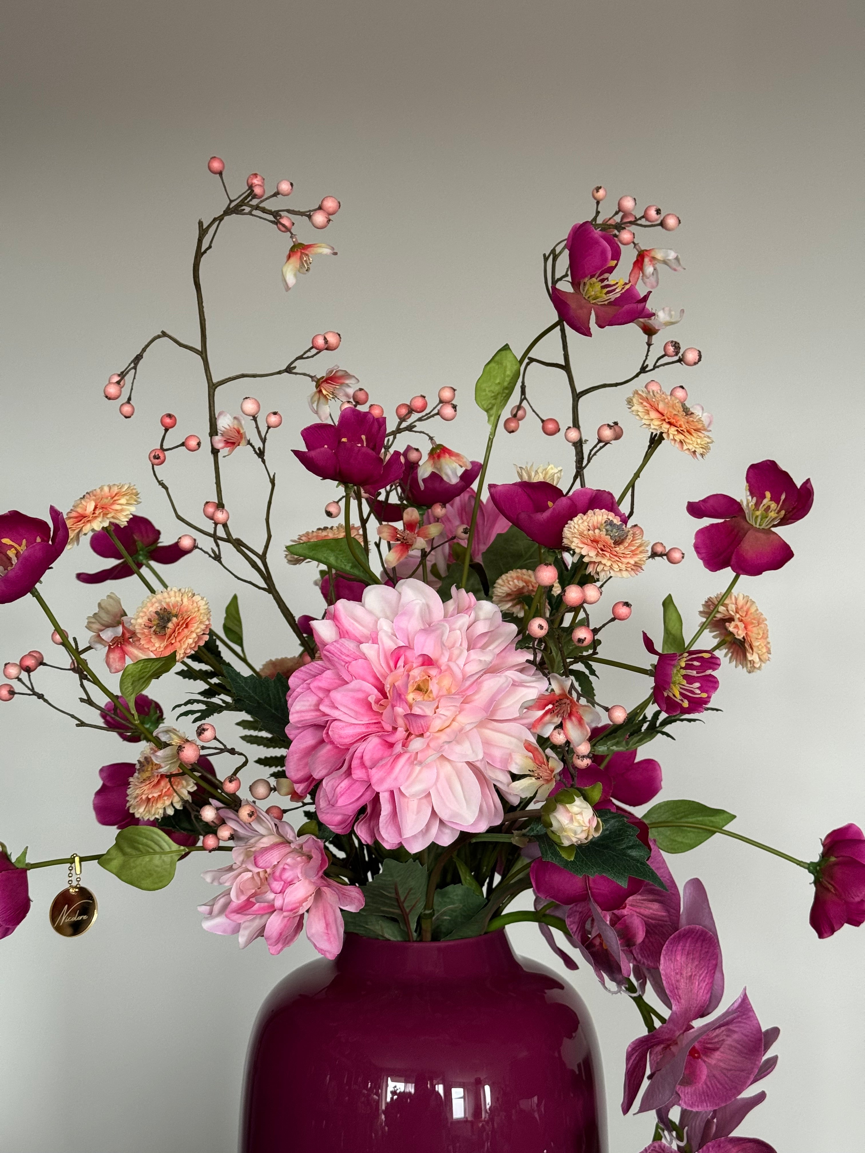 Zijden bloemen in roze tinten met decoratieve Silk-ka bessentakken.