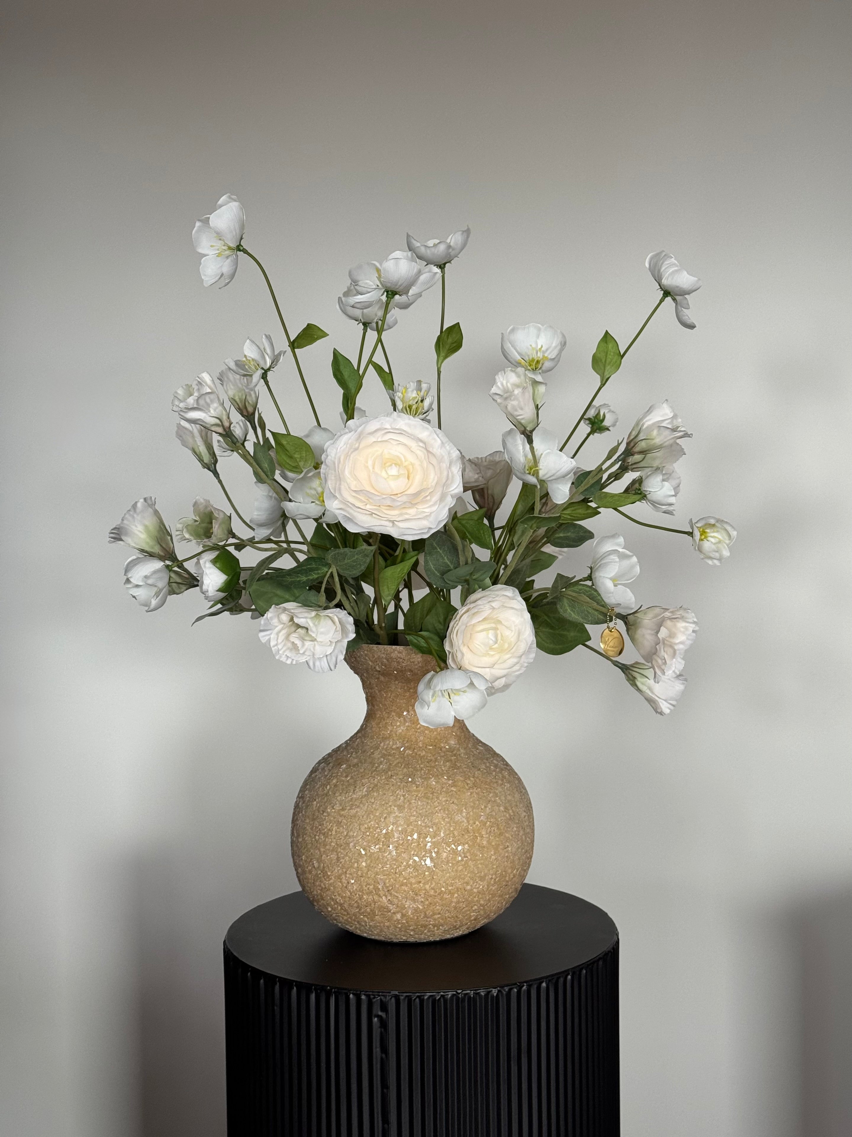 Hotel chique witte zijden bloemen in een elegante beige mozaïek vaas.