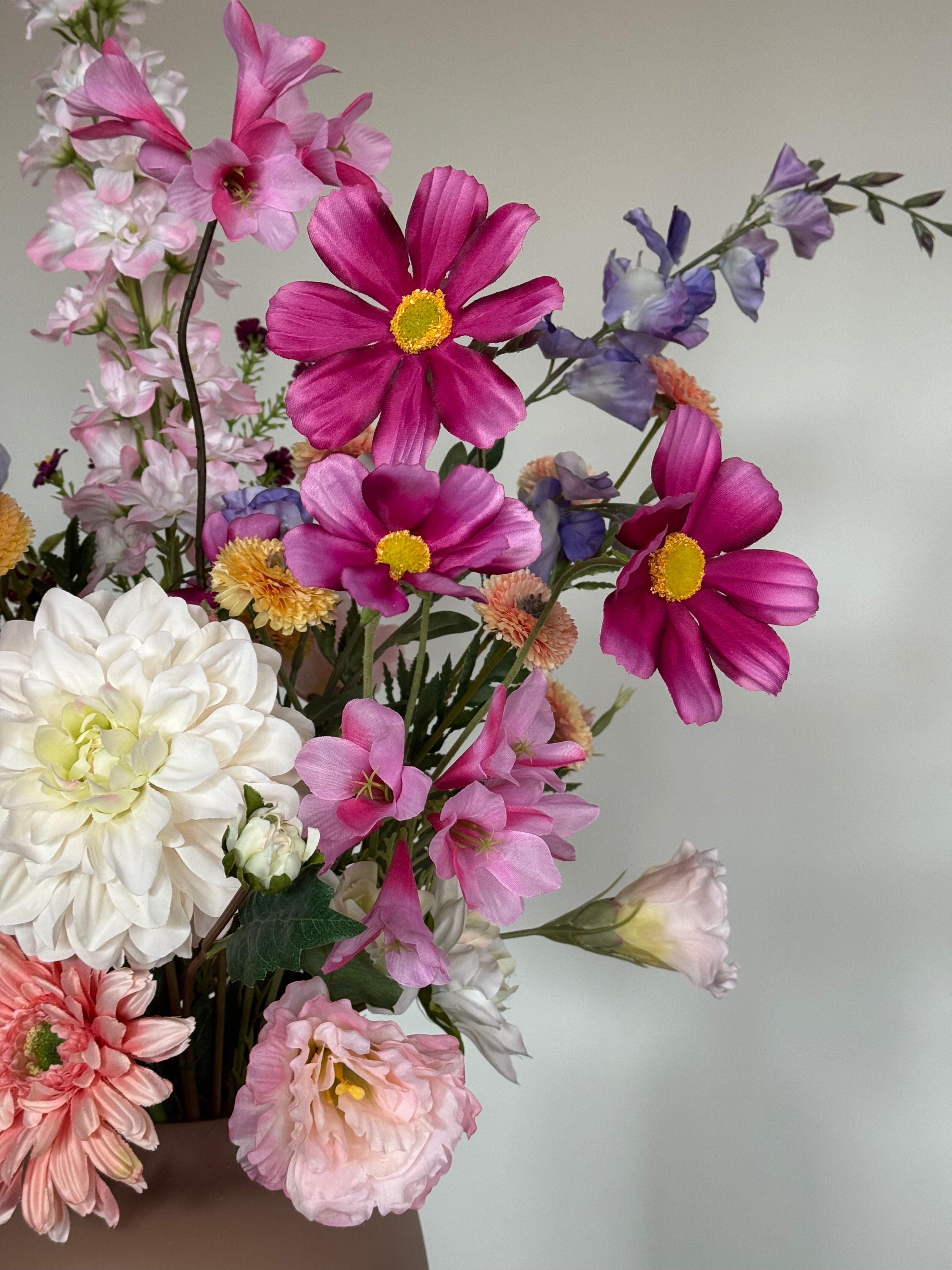 Detail van een kleurrijk zijden boeket met verschillende bloemsoorten.
