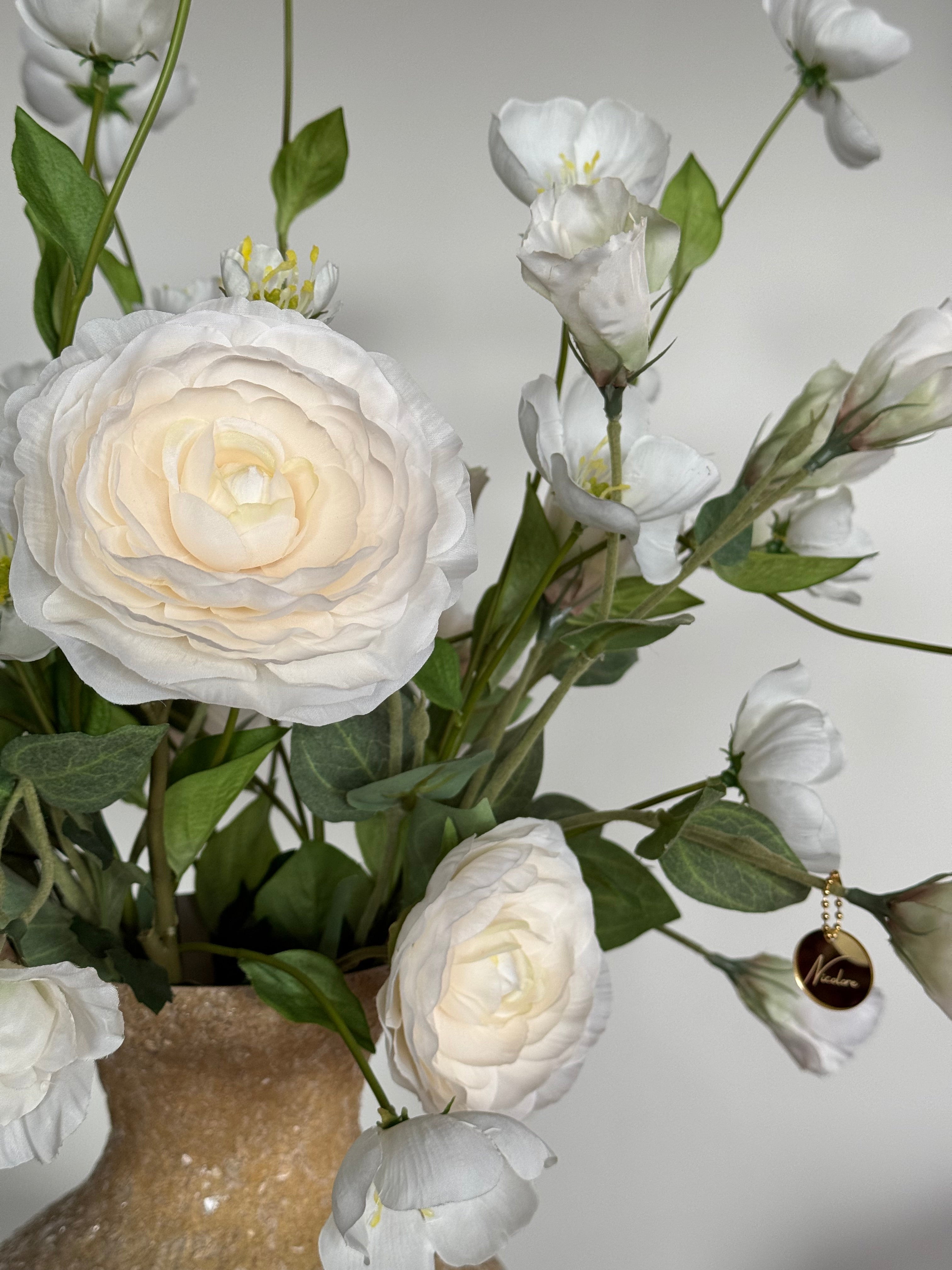 Luxe witte zijden bloemen met beige vaas als elegante woondecoratie.