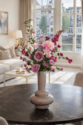 Elegant roze zijden boeket als blikvanger op een eettafel in een luxe appartement.
